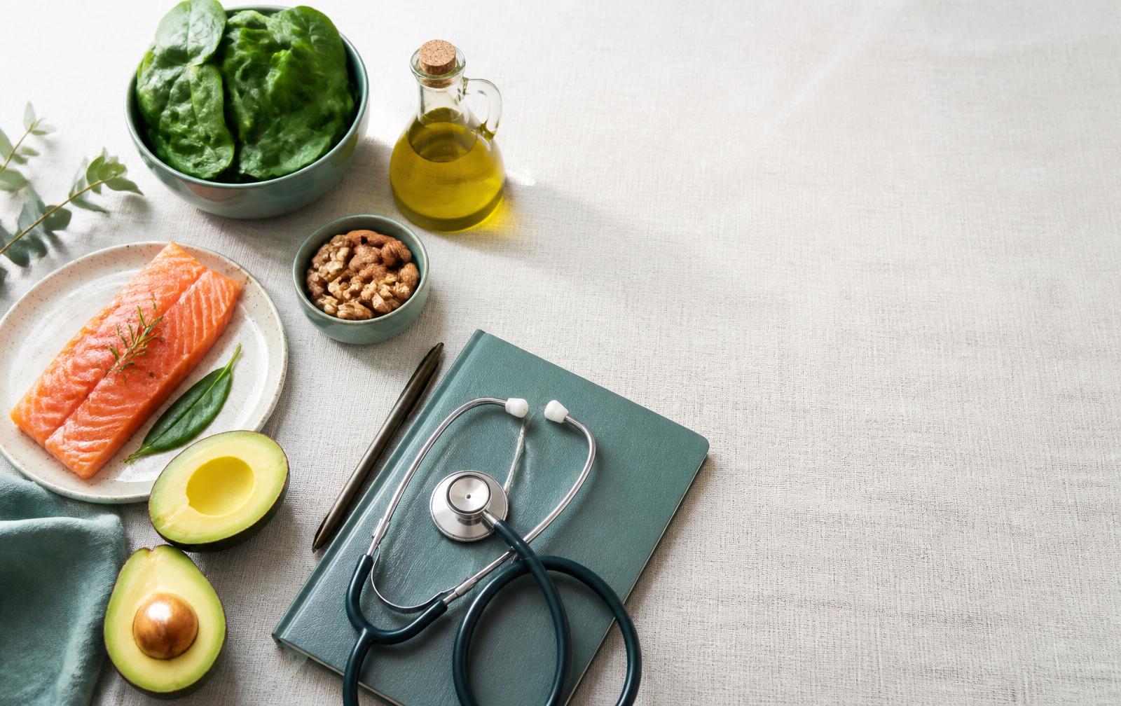 Alimenti della dieta chetogenica accanto a un quaderno clinico e uno stetoscopio